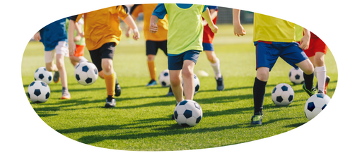 Children in bright coloured t-shirts dribbling footballs