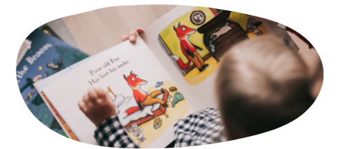 Young child sitting down reading a book