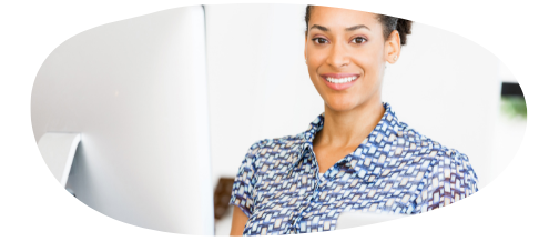 woman in blue pattern dress in front of a white laptop