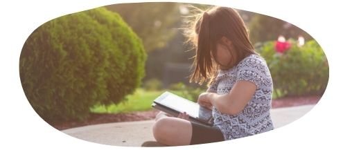 Girl on computer sitting down outside