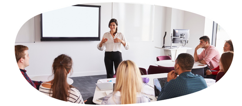 Teacher in a white shirt and navy trousers teaching a group of young people