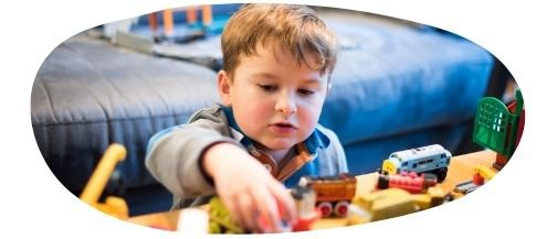 Young male child playing with toys and bricks on a table