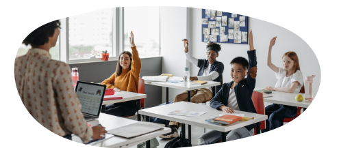 Young people with hands up in class with teacher