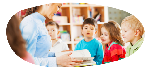 Four young children in school classroom listening to teacher read