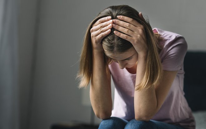 close-up-sad-young-woman-holding-her-head